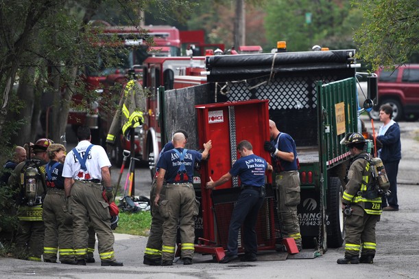 Ann Arbor firefighters navigate an 1100-pound door from a truck as they set up obstacles for training at Parkhurst Apartments on Wednesday morning. The complex is scheduled to be demolished and offers a good training ground for the firefighters. Melanie Maxwell I AnnArbor.com